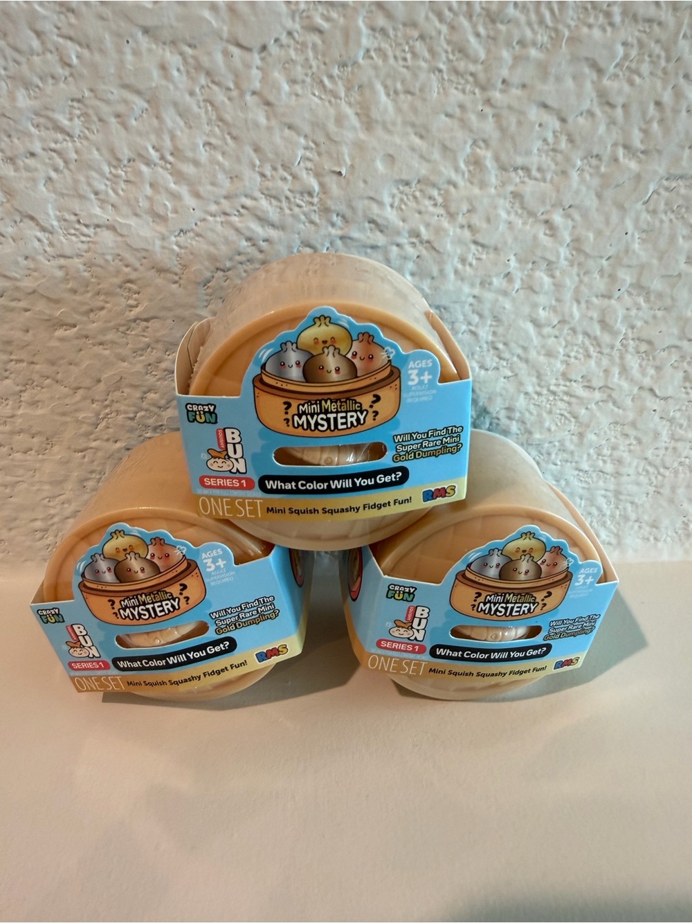 RMS Beauty Mini Metallic Mystery Squishy Pods in Peach and Light Blue Packaging